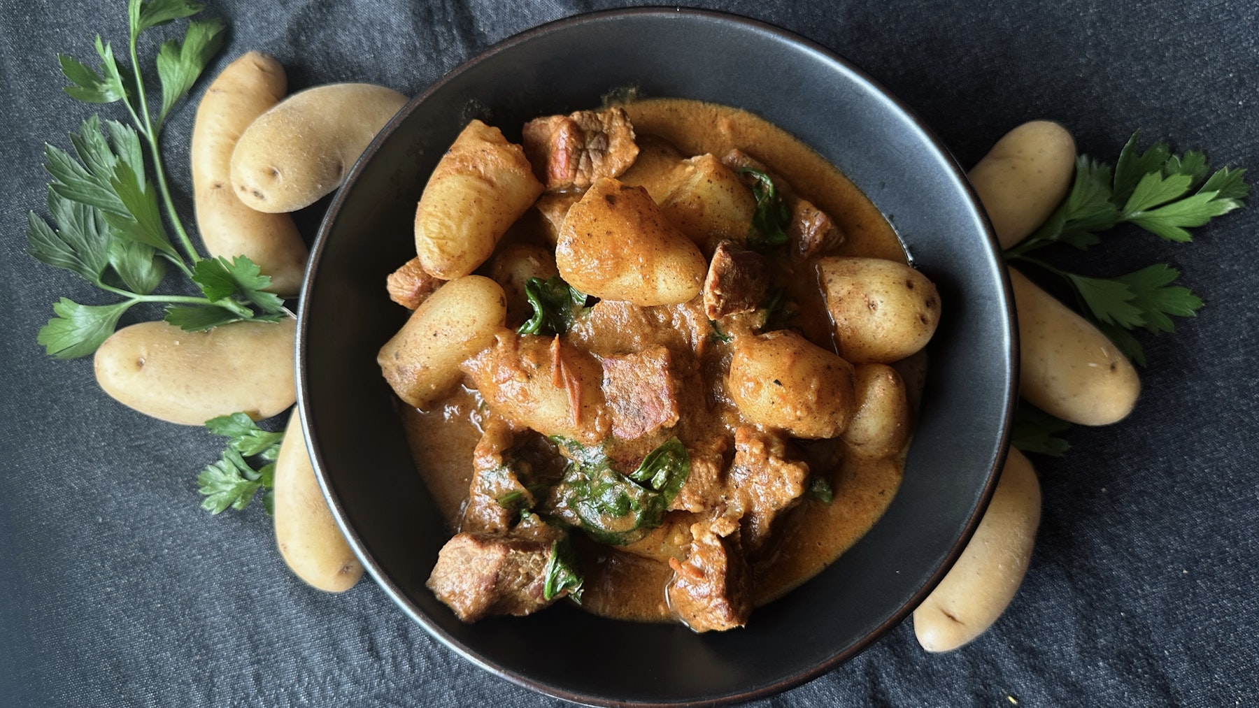 A bowl of peanut and beef stew filled with Little Fingerlings™.