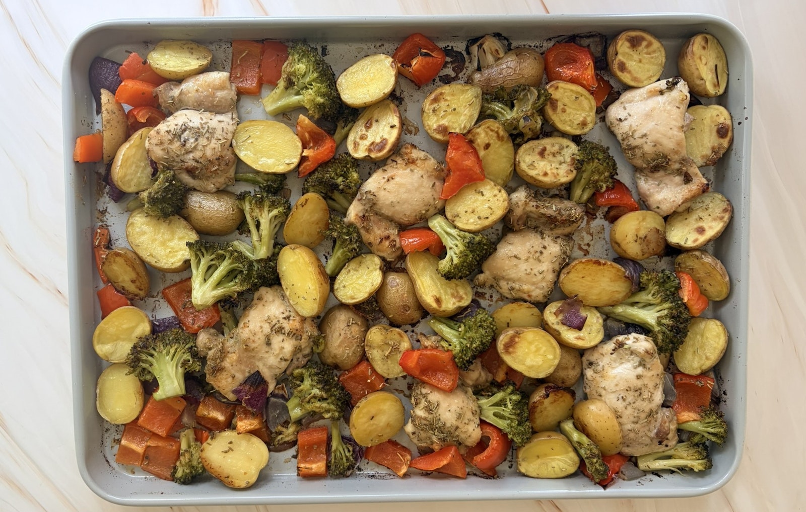 A sheet pan meal of chicken and veggies including A Little Homestyle Ranch™ Little Potatoes