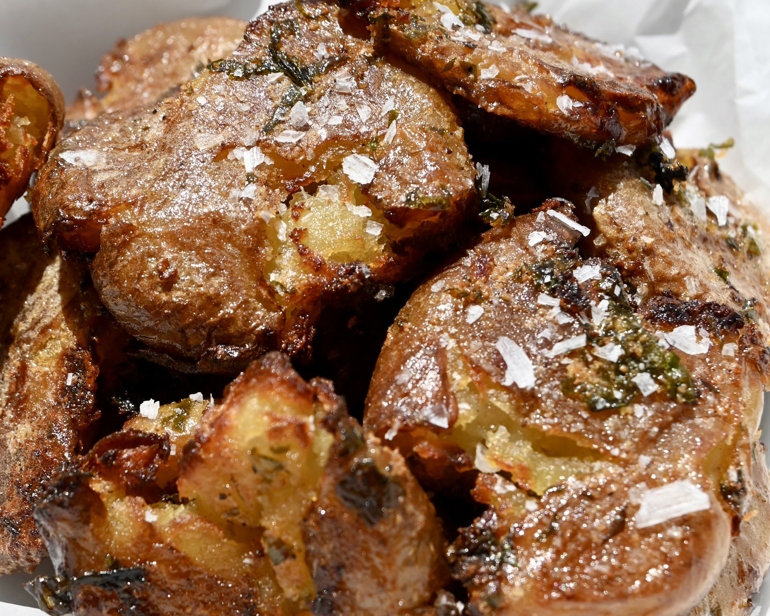 Some close up smashed potatoes covered in honey butter.