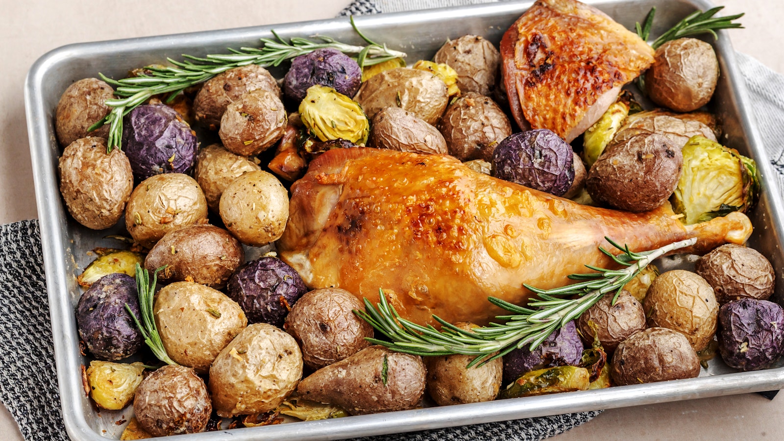 A sheet pan of Little Potatoes with turkey and rosemary.
